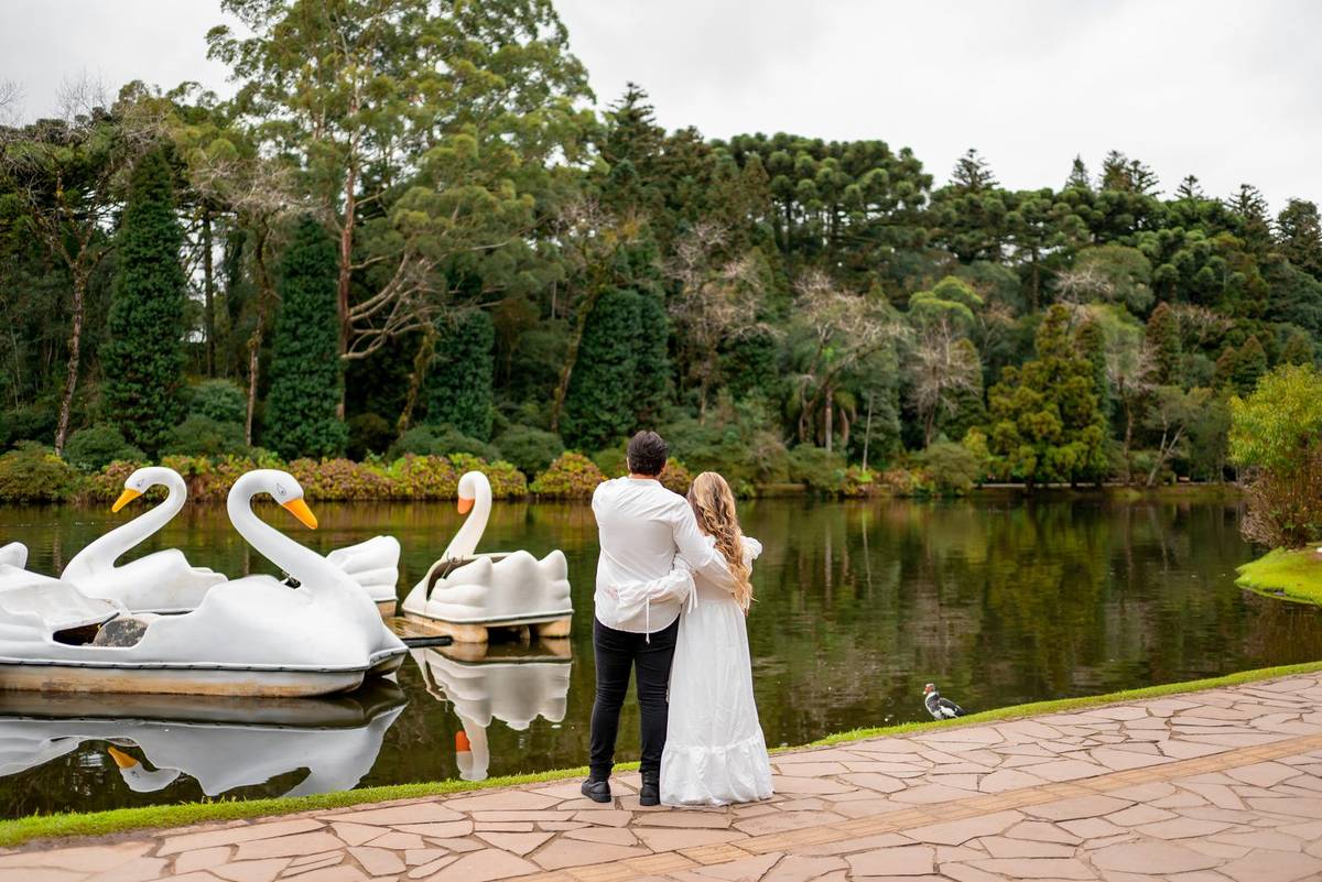 Casal abraçado diante dos pedalinhos do Lago Negro, em Gramado